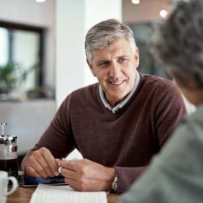Smiling man enjoys a conversation with his wife after applying for an Retirement Interest Only mortgage with the Marsden.