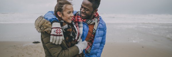 Young couple happy and smiling while walking on a beach
