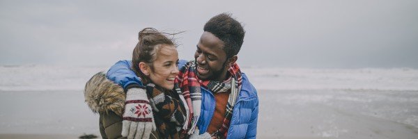 Young couple happy and smiling while walking on a beach