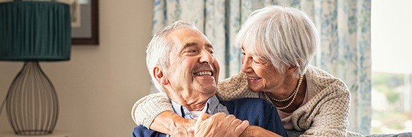 Older couple hugging at home on a sofa | Later Life mortgage case study